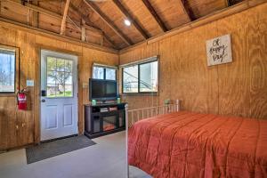 a bedroom with a bed and a tv and a door at Waterfront Studio with Fire Pit on Lake Dunlap! in New Braunfels