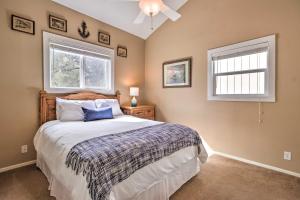 a bedroom with a large bed and two windows at Lakefront Home with Point Venture Golf Access! in Point Venture