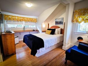 a bedroom with a bed and two windows at Leaside Manor in St. John's