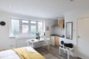 una camera da letto bianca con scrivania e cucina di (S3) Studio In South Harrow! a Harrow on the Hill