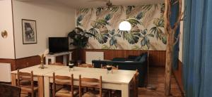 a dining room with a table and a couch at gîte résidence de la fontaine à Compreignac in Compreignac