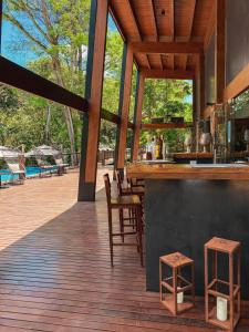 a bar on a deck with chairs and tables at Selvaje Lodge Iguazu in Puerto Iguazú