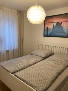 2 Einzelbetten in einem Schlafzimmer mit Kronleuchter in der Unterkunft Ferienwohnung Gartenoase in Dresden