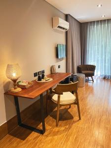 a wooden table with a chair and a living room at Selvaje Lodge Iguazu in Puerto Iguazú