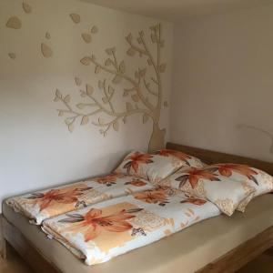 a bed in a bedroom with a tree on the wall at Ferienwohnung Friedrich in Mildenau