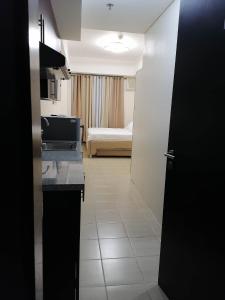een kamer met een keuken en een slaapkamer met een bed bij Fast Wifi 400 Mbps at Kasara Urban Resort Residences with Netflix and Pool Access in Manilla