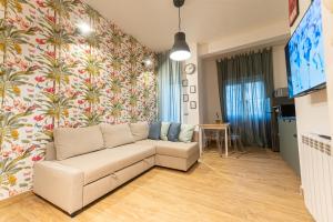 Casa Vacanze Partenope في نابولي: غرفة معيشة مع أريكة أمام الجدار