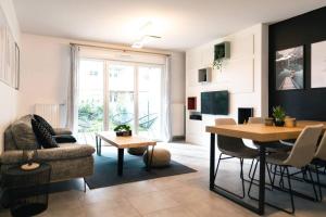 a living room with a table and a dining room at La Source Positive in Aix-les-Bains
