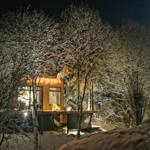 uma casa coberta de neve à noite em PASSION HUT em Salantai