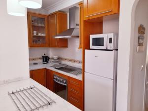 uma cozinha com um frigorífico branco e um micro-ondas em Pool View Apartment at Jumilla III em Playa Flamenca