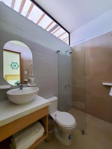a bathroom with a sink and a toilet and a mirror at SUITES BRISAMAR PLAYA SANTA MARIANITA Manta in Manta