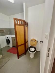 a bathroom with a toilet with a wooden door at Appartement OTP2 de standing proche plage et lagon in La Saline les Bains +44 photos
