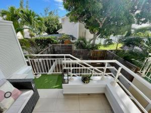 a balcony with a white railing and a bench at Appartement OTP2 de standing proche plage et lagon in La Saline les Bains