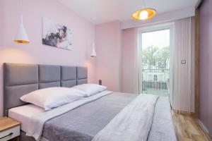 um quarto com uma cama grande e uma janela em Apartament Porto Santa Rewales em Rewal