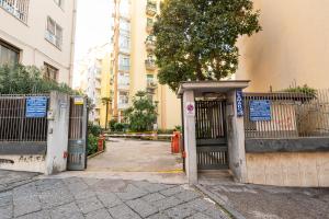 un ingresso a un edificio con cancello e albero di Casa Vacanze Partenope a Napoli