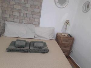 a bed with two pillows on it with a night stand at A Toca do Cuco na Vila da Sertã in Sertã