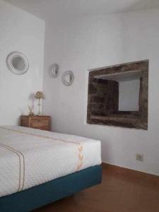 a bedroom with a bed and a mirror on the wall at A Toca do Cuco na Vila da Sertã in Sertã