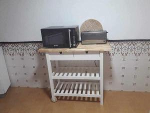 a microwave sitting on top of a white table at A Toca do Cuco na Vila da Sertã in Sertã