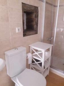 a white bathroom with a toilet and a shower at A Toca do Cuco na Vila da Sertã in Sertã