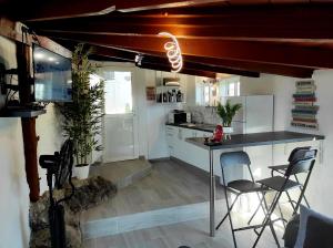eine Küche mit einer Theke und Stühlen in einem Zimmer in der Unterkunft Etoile arc-en-ciel in Tejina de Isora