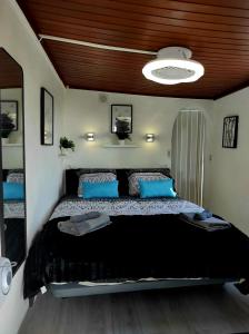 a bedroom with a large bed with blue pillows at Etoile arc-en-ciel in Tejina de Isora