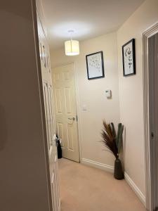 a hallway with a white door and a potted plant at stylish luxe apartment in Harlow