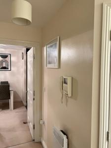 a hallway with a tv on a wall at stylish luxe apartment in Harlow