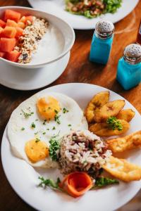 um prato branco de comida com ovos e batatas fritas em Nicawaves em Popoyo