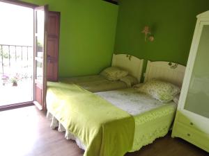2 camas en una habitación con paredes verdes en El Limonero, en Arenas de Iguña