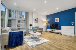 a living room with a couch and a tv at Contemporary and Stylish 2 Bed in Nine Elms in London