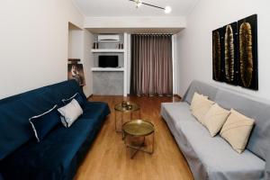 salon z niebieską kanapą i stołem w obiekcie Our House Luxury Suites w mieście Palaión Tsiflíkion