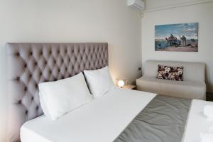 パレオ・ティフリキにあるOur House Luxury Suitesのベッドルーム(大型ベッド1台、椅子付)
