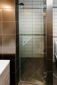 prysznic ze szklanymi drzwiami w łazience w obiekcie Our House Luxury Suites w mieście Palaión Tsiflíkion +16 zdjęć