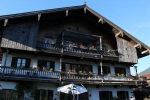 a building with a balcony with flowers on it at Ferienwohnungen Gruber in Kiefersfelden