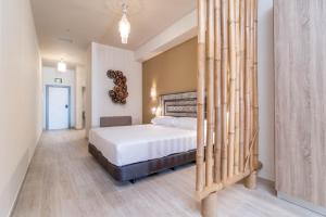 een slaapkamer met een bed met bamboestokken erin bij Tarifa Suites by QHotels in Tarifa
