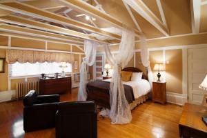 1 dormitorio con cama con dosel y sala de estar. en Leaside Manor en San Juan de Terranova