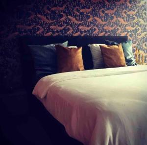 a bed with many pillows on it in a bedroom at OEVER51: Slapen aan het water in Aalst