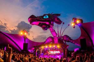 a crowd at a music festival with a dragon float at OEVER51: Slapen aan het water in Aalst