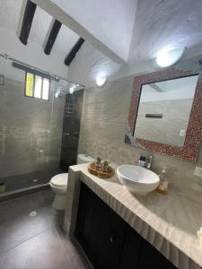 uma casa de banho com um lavatório, um WC e um espelho. em Casa de Descanso em Melgar