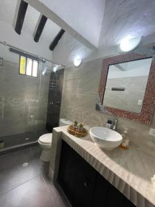 a bathroom with a sink and a toilet and a mirror at Casa de Descanso in Melgar