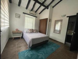 um quarto com uma cama, uma mesa e janelas em Casa de Descanso em Melgar