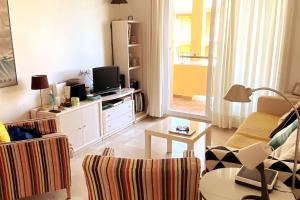 een woonkamer met een bank en een tv bij Novo Sancti Petri, La Barrosa, 2 Beds Room Apartamento by Chiclana Dreams in Chiclana de la Frontera