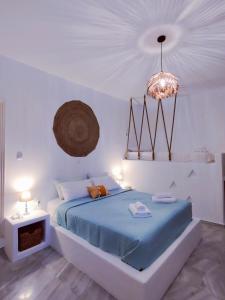 a bedroom with a blue bed and a chandelier at Litus Studios in Megas Gialos - Nites