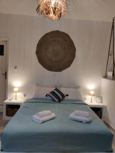 a bedroom with two towels on a bed with a chandelier at Litus Studios in Megas Yialos-Nites