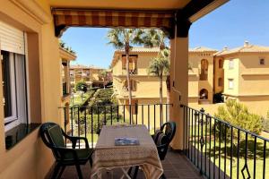 een patio met een tafel en stoelen op een balkon bij Novo Sancti Petri, La Barrosa, 2 Beds Room Apartamento by Chiclana Dreams in Chiclana de la Frontera