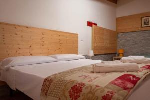 a bedroom with two large beds with white sheets at Agriturismo Dai Mori in Isola del Piano