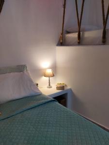 a bedroom with a bed and a lamp on a table at Litus Studios in Megas Gialos - Nites