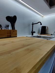 a kitchen with a sink and a wooden counter top at Litus Studios in Megas Yialos-Nites