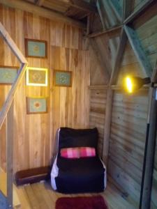 um quarto com uma cadeira no sótão em Unique Glamping / Domo Betsaida em Guatapé