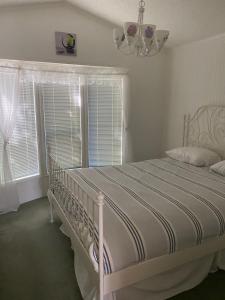 1 cama blanca en un dormitorio con ventana en Beaver Lake Resort Site #36 en Lake Cowichan